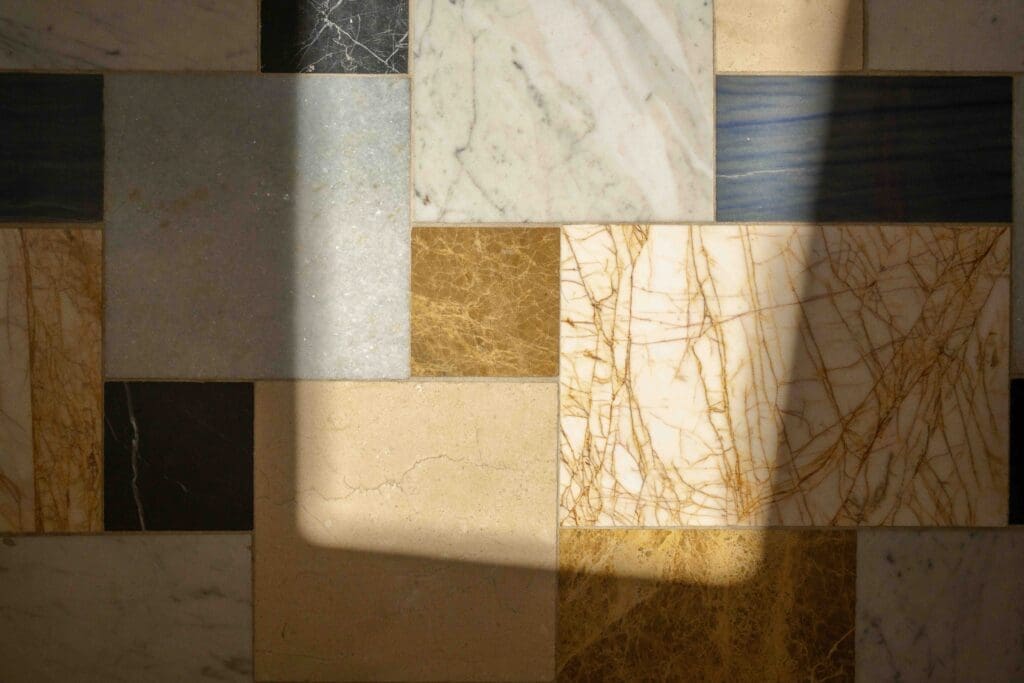 Custom mosaic marble floor with mixed stone varieties over radiant heat in a Hollywood Hills mid-century modern bathroom by The Warren.